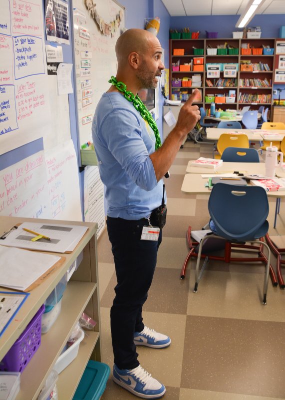 Assistant Principal Alfredo Rodriguez explains to fifth-grade students how the process of selecting their rewards will work.