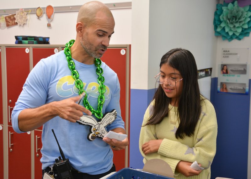 Assistant Principal Alfredo Rodriguez shares a special reward menu with Rebeca Tzun-Rivas, who selected a positive call home from her principal or assistant principal.