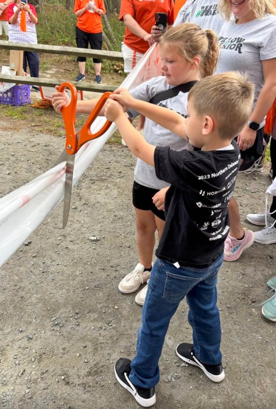 National Kidney Foundation youth ambassadors Willow Miller, back, and Dawson Davis cut the ribbon at the walk.