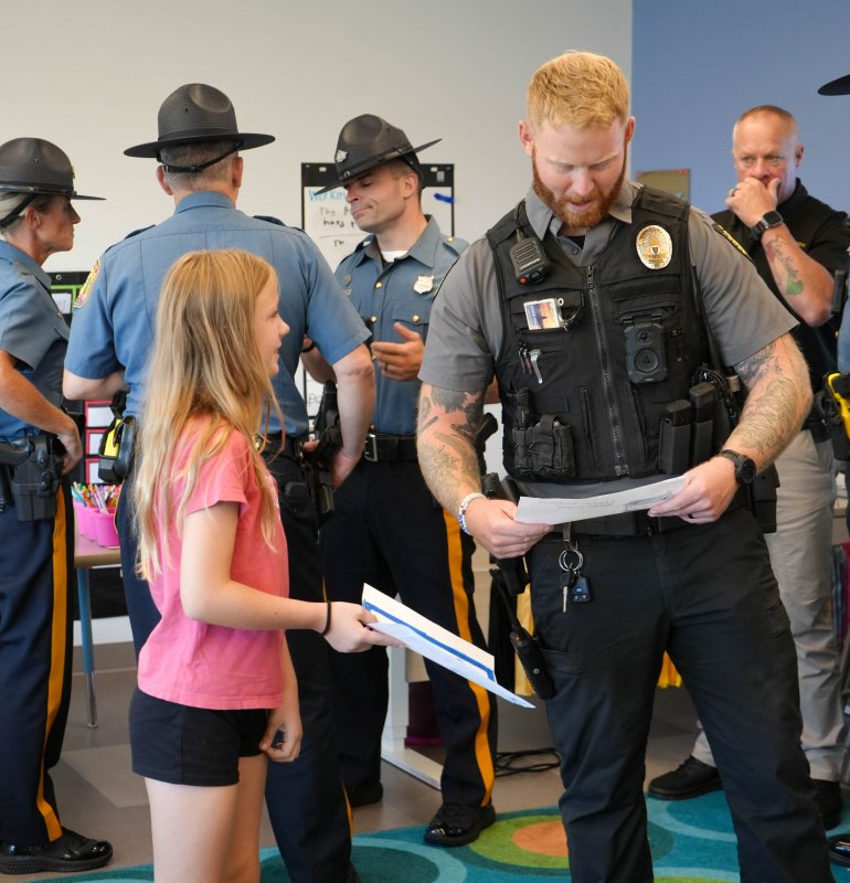 Claire Dacheux gives a thank-you note to Lewes Cpl. Nick Yatsko, who serves as a student resource officer at Lewes Elementary and Fred Thomas Middle.