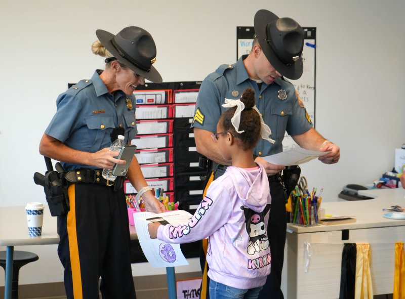 Karmella Henry gives thank-you notes to Lt. Heather Pepper, left, and Sgt. Nicholas DeMalto of the Delaware State Police.