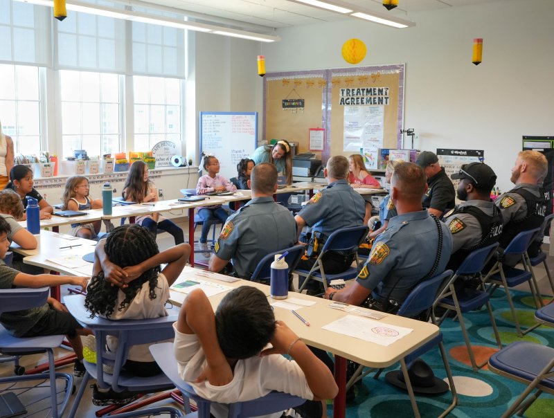 Students sit and ask the officers questions.