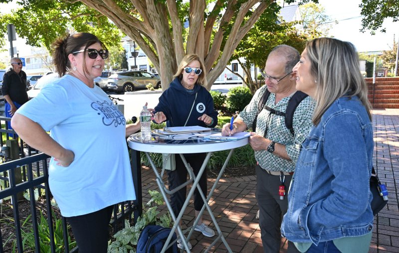 Tiffany Lionetti, left, and Leeann Augustine from the Freedom Boat Club get signatures on the tour waiver from visitors Eric and Sue Cohen.