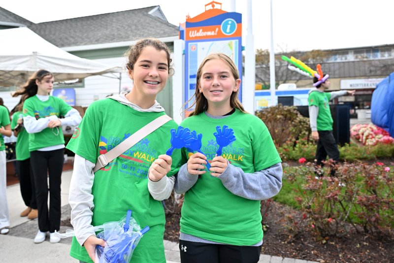 McKayla Veith, left, and Haley Yeich of Mariner Middle School distribute clappers before the Buddy Walk.