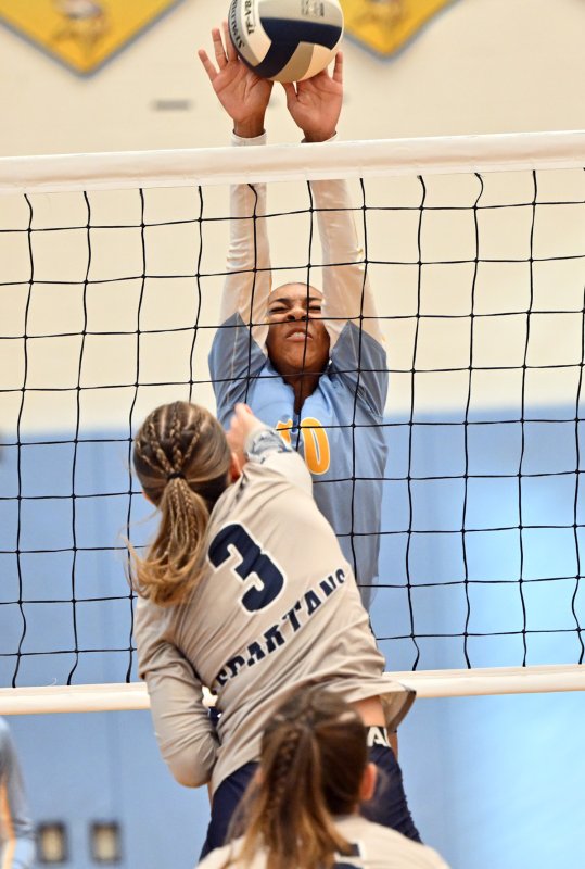 Cape’s Journey McDaniel blocks a kill attempt from Lake’s Lilly Hoyd.