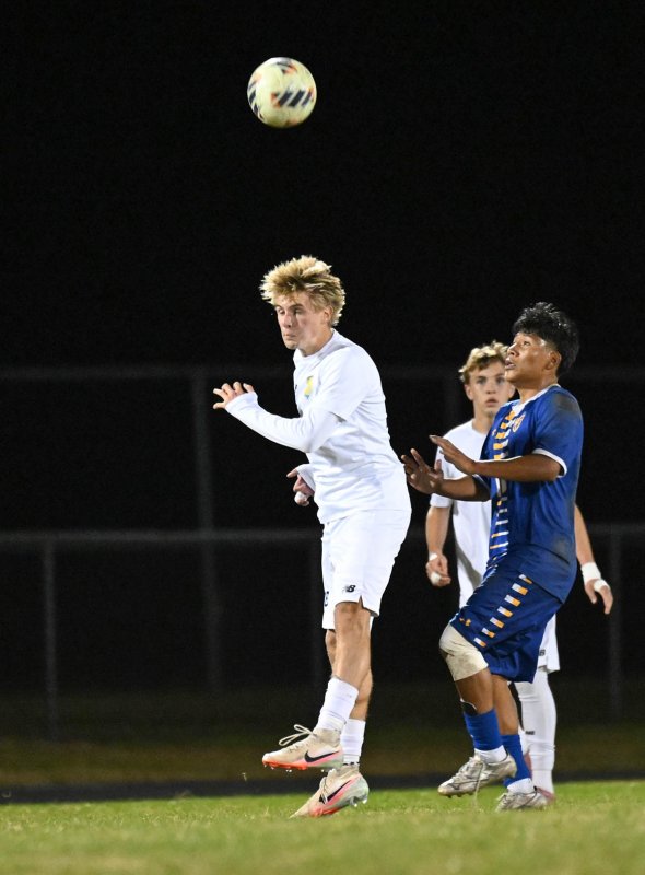 Seth Benjamin heads a clear in the midfield.