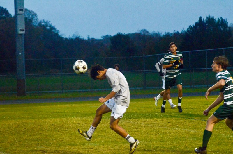 Sussex Academy sophomore Bodhi Williams heads the ball away.