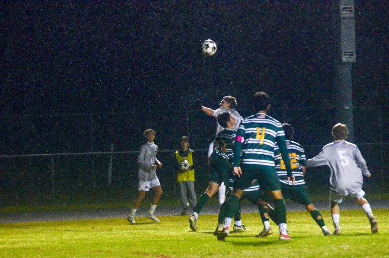 Sussex Academy senior Chase Ballinger battles the wind and rain to flick the ball.