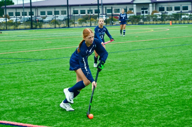 Sussex Academy freshman Emma Orlen carries along the boundary.