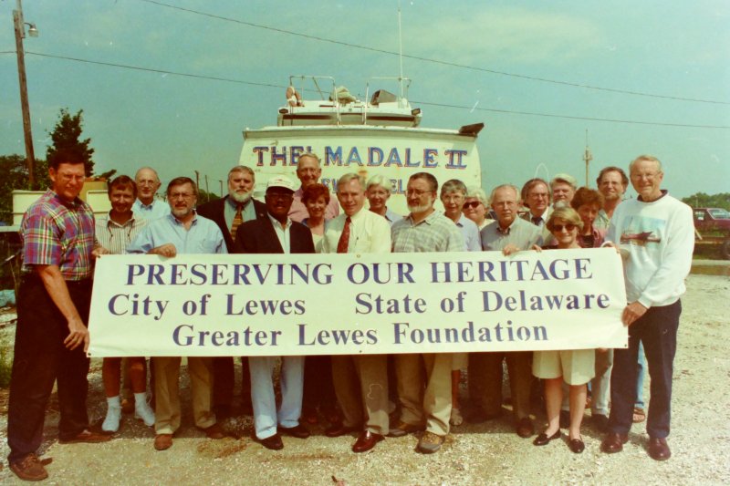 On hand for the announcement that Delaware, Lewes and the Greater Lewes Foundation have formed a partnership that is closing in on purchase of the Lewes Boatyard property was this group of Lewes-area residents involved in the project. They are (l-r) Michael Clemmer, executive director of Greater Lewes Foundation; Gavin Braithwaite; Ralph Richardson; Ted Kanakos of the Lightship Overfalls friends group; Lewes Councilman Jud Bennett; Lewes Mayor George H.P. Smith; David Burton, foundation board member; Lewes Chamber of Commerce Executive Director Betsy Reamer; 37th District Rep. John Schroeder; Ann Burton; Lewes Councilman Jim Ippolito; Wendy Richardson; Sally Packard; Greater Lewes Foundation Vice Chair Joe Stewart; John Mateyko; Dinah Reath; Richard Anthony; Becky Forney; Greater Lewes Foundation Chair Dennis Forney; and John Thorsen of the Lightship Overfalls friends group. SOURCE: CAPE GAZETTE ARCHIVES