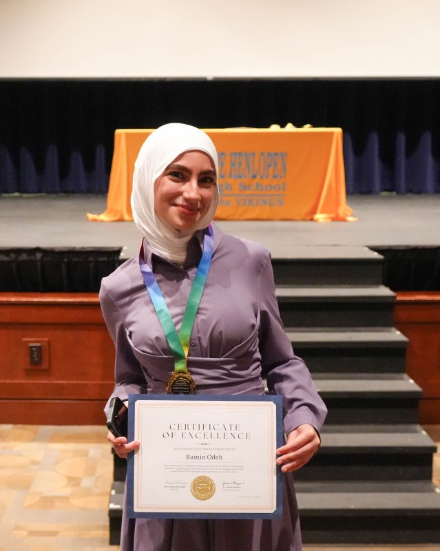 Cape student Ramin Odeh dons a medal and holds up a certificate, both of which she received at the ceremony for demonstrating English proficiency.