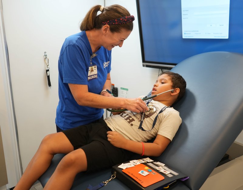 Noelle Mills, a registered nurse with Beebe Healthcare, helps Sussex Consortium student Darkyr Major listen to his heartbeat through a stethoscope. The two are in Beebe’s Community Mobile Health Clinic.