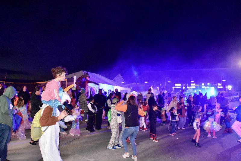 A large crowd dances the night away in front of the pop-up stage.