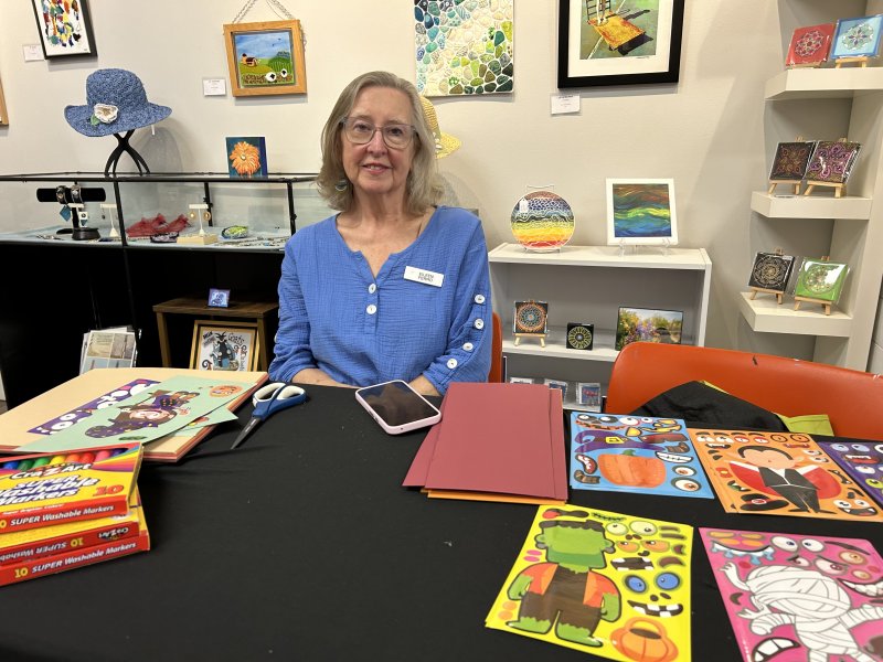 Eileen Ferro poses at the Milton Arts Guild’s home base on Federal Street selling her children’s works.