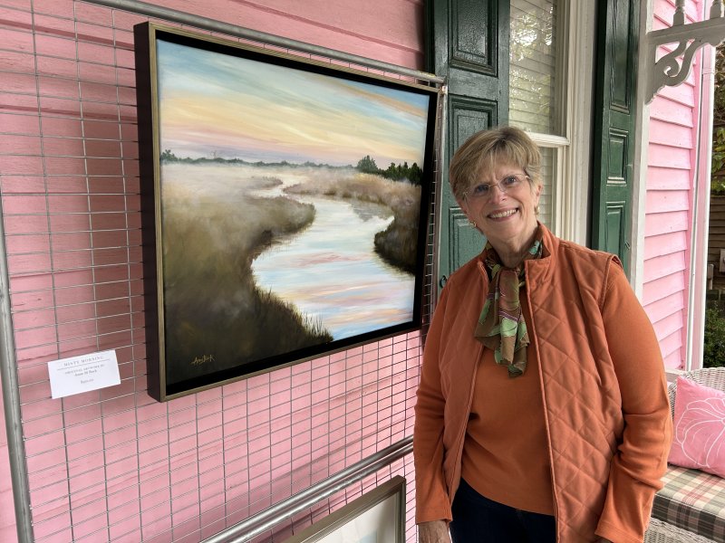 Anne Buck poses with her oil painting titled “Misty Morning.”