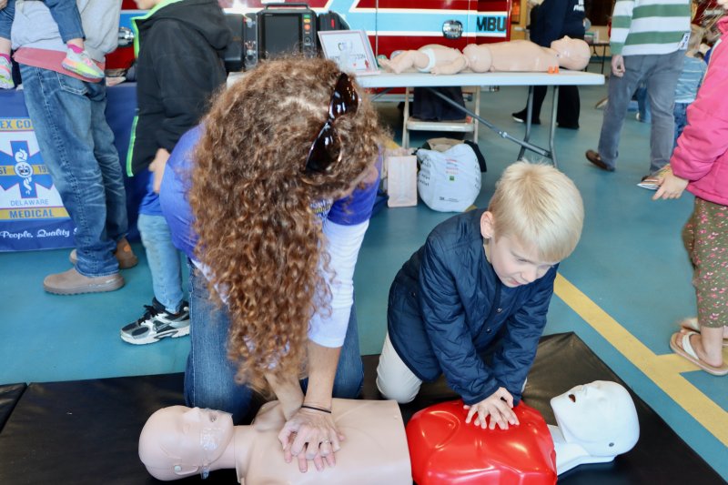 Corey Kennedy of Beebe Healthcare teaches 6-year-old Tristyn Jacoby how to do CPR.