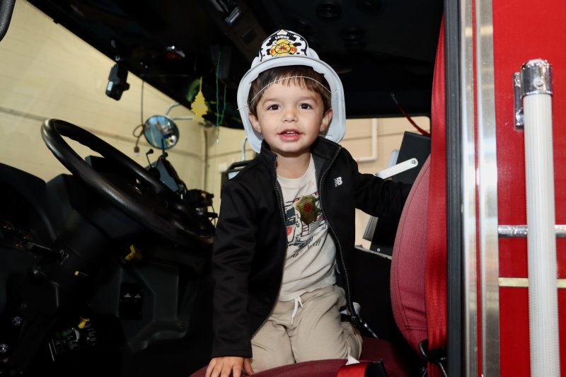 Braden Hutchinson of Milton looks like a firefighter wearing his helmet and sitting the front seat of a fire truck.