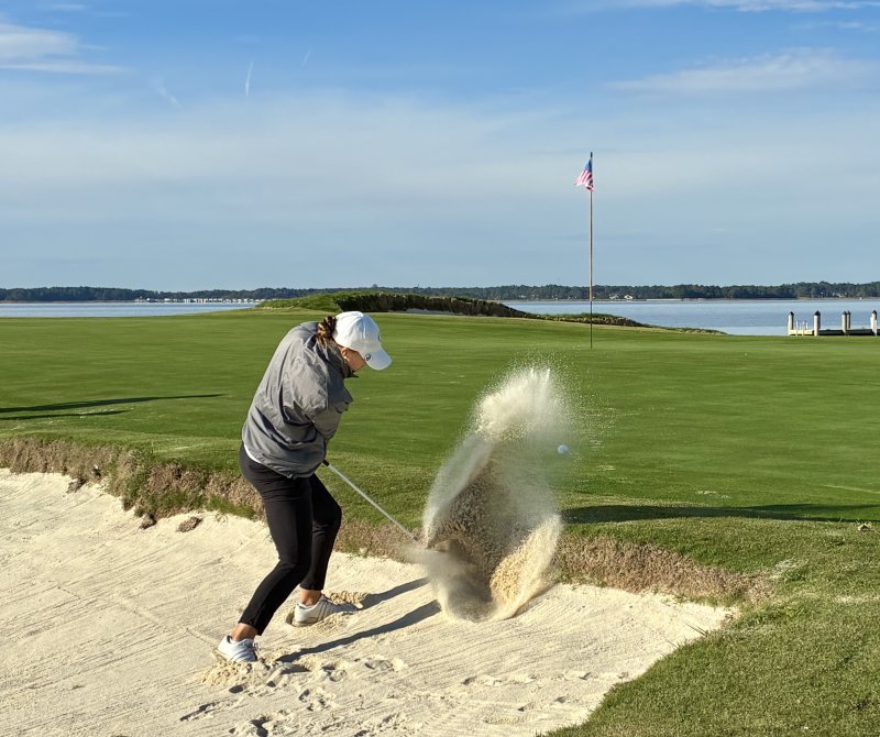 Tekla Fine-Lease blasts out from a fried-egg lie at the 140-yard par 3 19th hole at Rehoboth Beach CC, which served as the 10th hole in the Oct. 18-19 Lady Blue Hen Invitational college golf tournament. FRITZ SCHRANCK PHOTOS