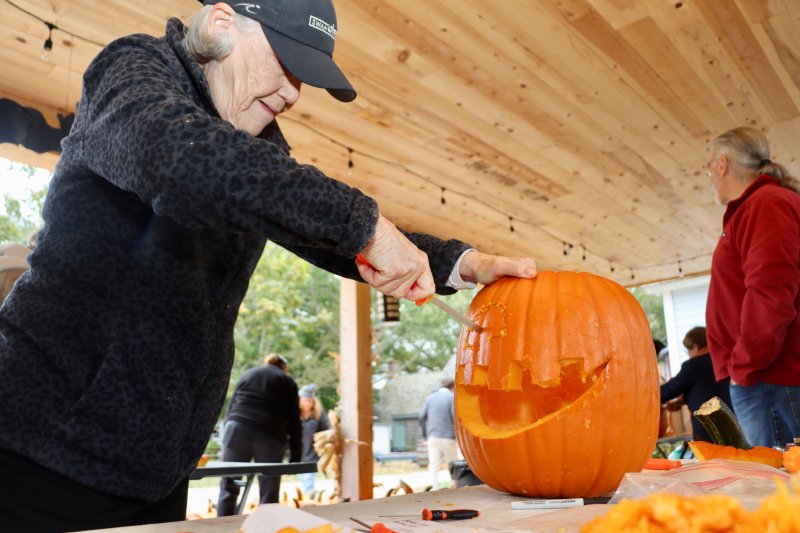 Rosemary Ewing, a member of the Zwaanendael Women’s Club and Lewes in Bloom, works hard to put a big smile on her pumpkin.