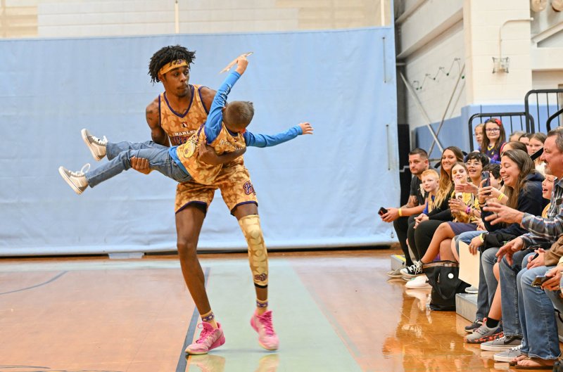 Harlem Wizard “Too Tall,” aka Devale Johnson, feints throwing a fan back to his parents.