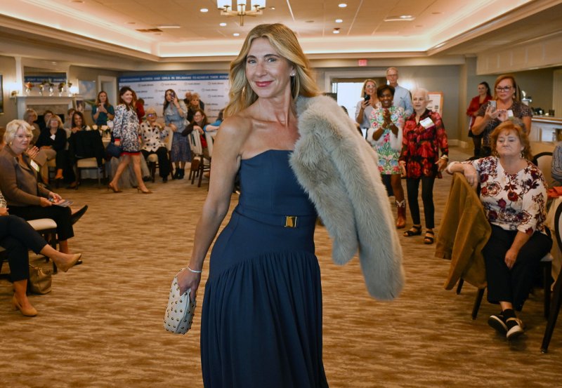 Stephanie Weiss wears an elegant blue strapless maxi dress, faux fur jacket and Dolce Vita studded bag from Brooklyn Boulevard. DAN COOK PHOTOS