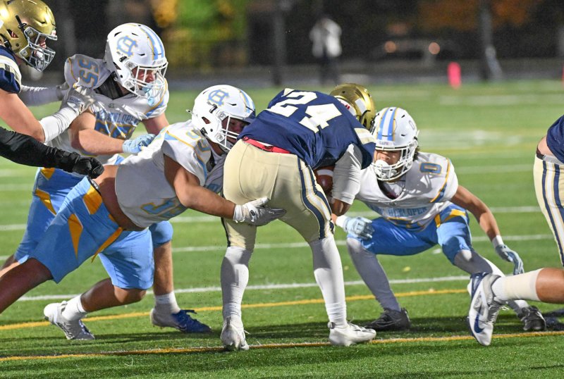 Cape defensive players (l-r) Mason Schaffer, Javier Morales-Roblero and Andrew Messick gang tackle Sallies running back EJ Cotton.