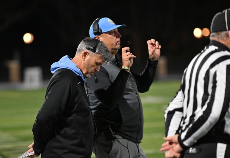 Cape assistant coach Jason Pease signals in a play to quarterback Mikey Thompson.