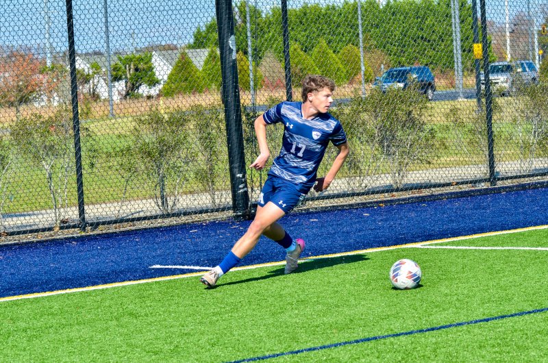 Sussex Academy senior Chase Ballinger rounds out his run for the ball near the Cape end line.