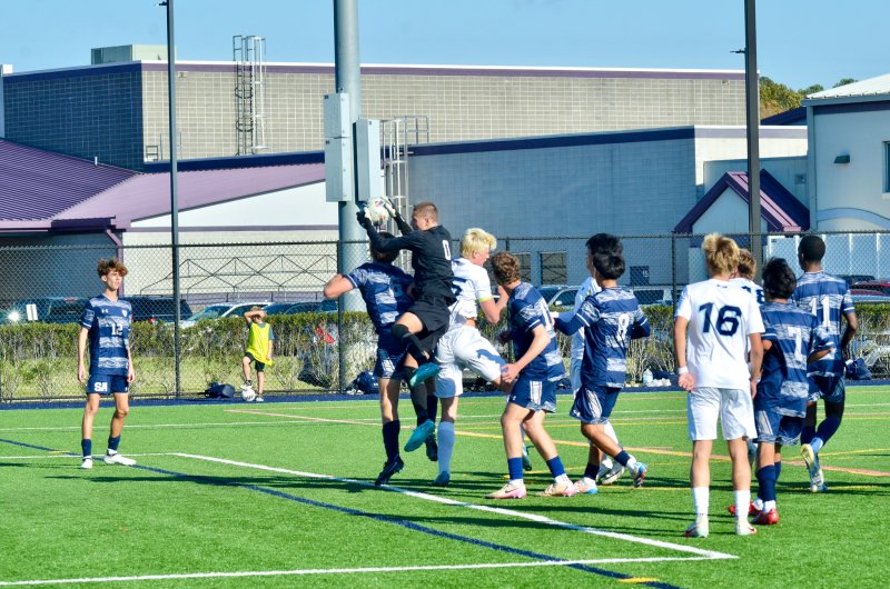 Seahawks senior Austin Taylor fights to capture a cross.