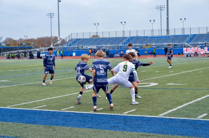 Sussex Academy eighth-grader Nico Haskell, left, and Liam Stegall try to win a ball against Saint Mark’s senior Gabriel Arick while Noah Benz looks to posses away from the mess.