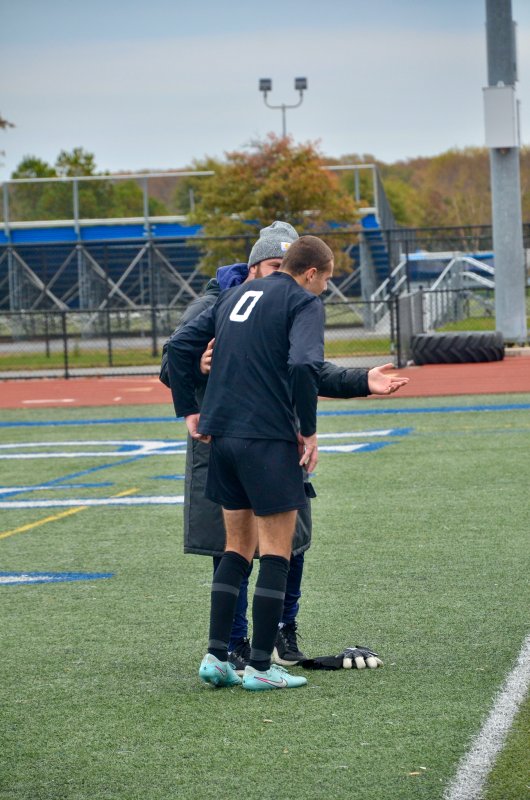 Sussex Academy head coach R.J. Dina explains to Austin Taylor that he has no reason to hang his head down after a brilliant season and championship game as the Seahawks keeper.