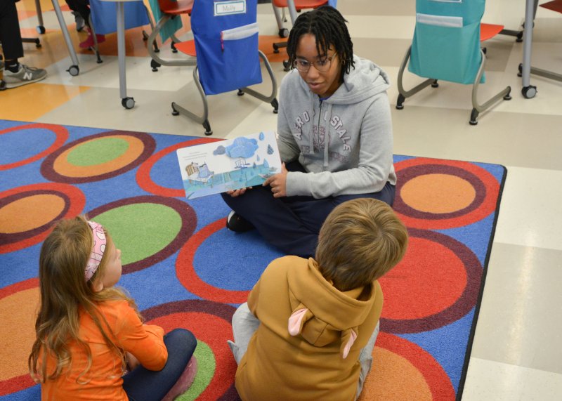 Love Creek students Rylee Mulvaney and Keanu Sharp listen intently as Robyn Anadu of Beacon MS reads “The Color Monster.”