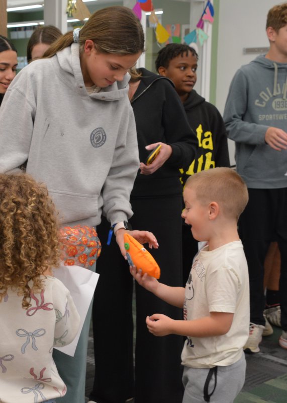 Noah Denehy, a Lewes Elementary kindergartener, is delighted to receive his monster from Ellie Burris of Fred Thomas MS.