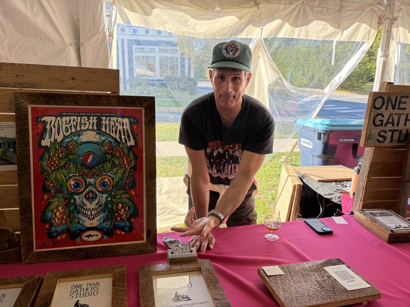 Dogfish Head founder Sam Calagione shows off picture frames and woodwork made out of saved barn wood from Dogfish Head’s original location at 320 Rehoboth Ave. and handcrafted by artisan Matt Meyers.