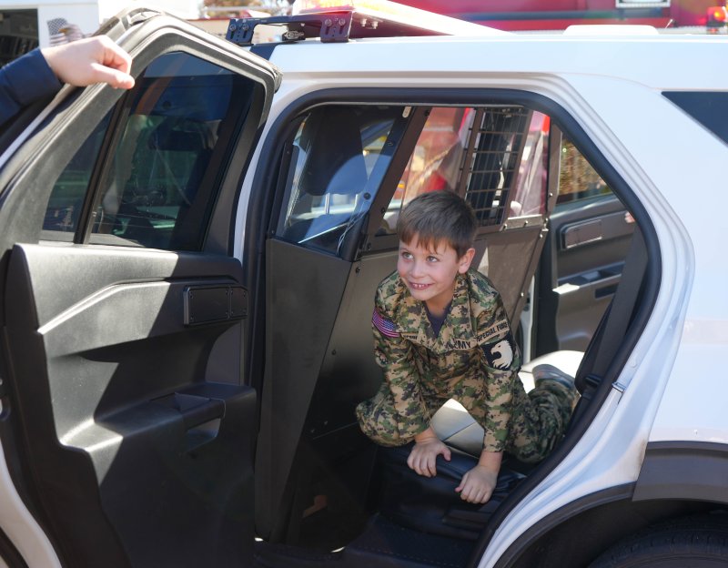 Jack Smith climbs across the back seat of a Georgetown Police car.