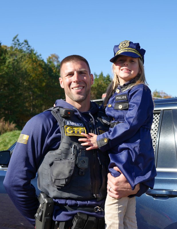 Delaware State Police Cpl. Daniel Korenyi, left, holds his daughter, Kollins, who’s wearing a matching police officer costume.