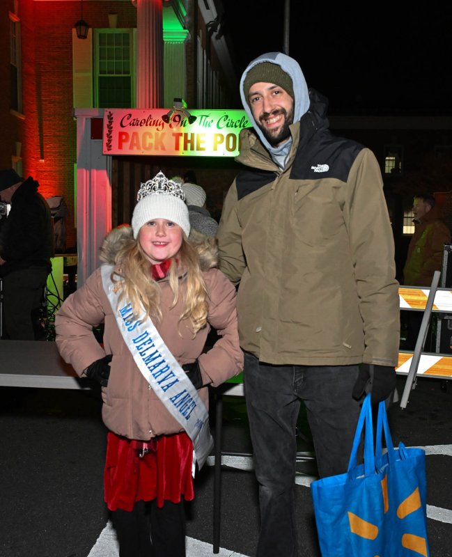 Aubrey Zinser, 9, and her dad Evan donate food goods to the Pack the Pod.