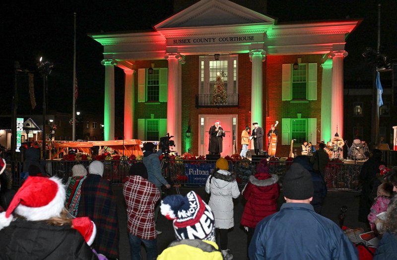 Kevin Short and Ed Shockley lead the caroling from the stage in front of the historic Sussex County Courthouse.