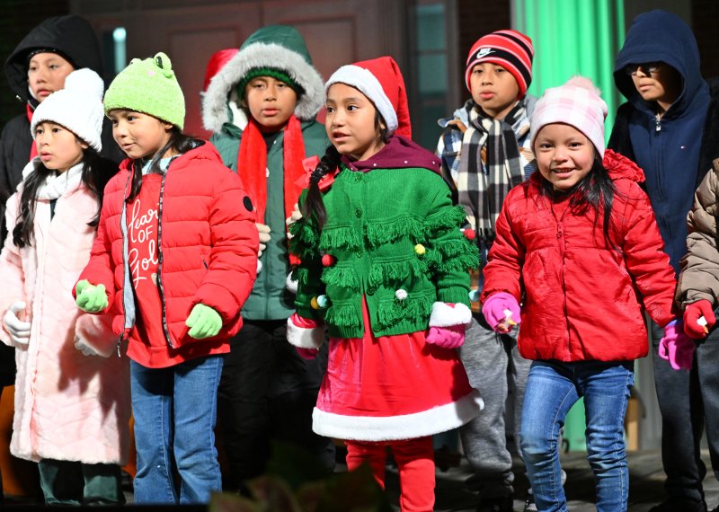 Singers from the children’s choir of St. Michael’s Catholic Church entertain the crowd with their Christmas song “Mi Burrito Sabanero.”