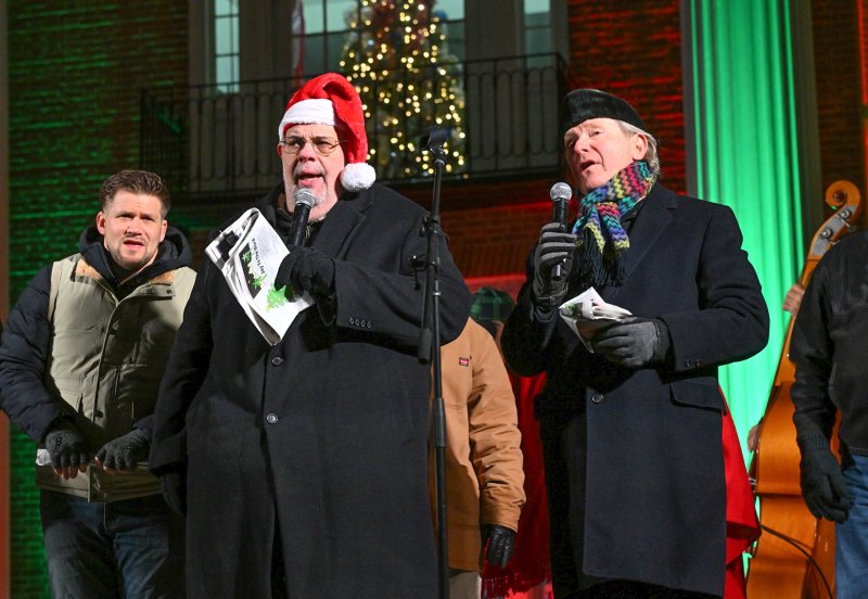 Kevin Short, center, and Ed Shockley lead the carolers in singing “Silent Night.”