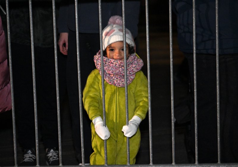 Elle Bay, 2, watches the parade from behind the barrier.