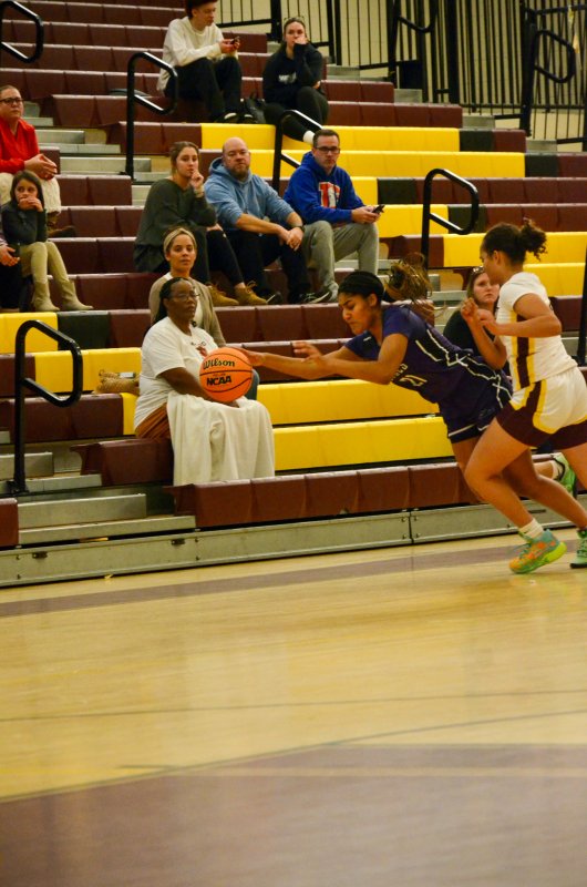 Delmarva Christian senior Eva Elliott tries to control a loose ball. In the background, former Royal Layni Dukes watches the effort. Dukes had to attend club volleyball practice at University of Delaware after helping her former teammates.