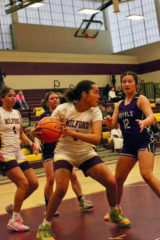 Milford junior Bella Watson guards her rebound.