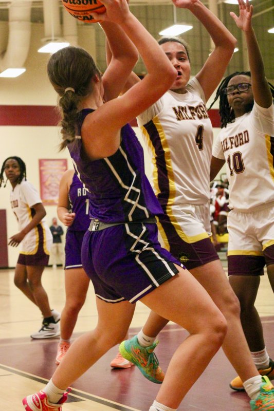 Milford junior Bella Watson applies pressure on Eve Bohinski at the baseline.