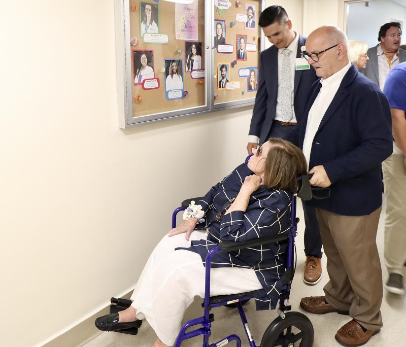 Peggy Rollins admires photos of Beebe’s resident physicians inside the Shaw Building in 2024. She joined her family that day for the unveiling of the R. Randall Rollins Center for Medical Education. Rollins once worked in the billing department in the building. BILL SHULL PHOTO