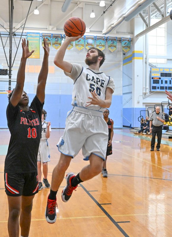 Cape junior Jaxon Benton goes in for a basket on Polytech’s Amire Robinson.
