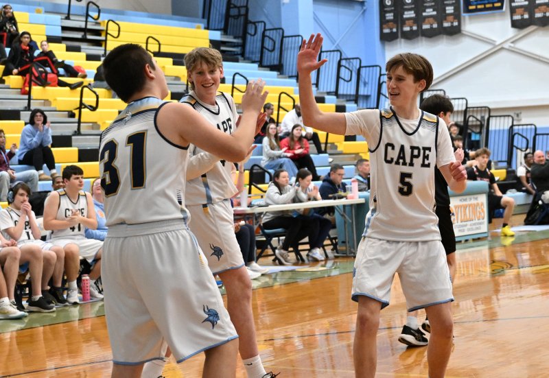 Cape’s Julian Puente gets congratulations on his basket from teammates Erichson McMahon, center, and Parker Bishop.
