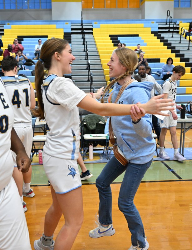 Junior unified partner Camilla Willis, left, celebrates the win with assistant coach Elle Nauman.