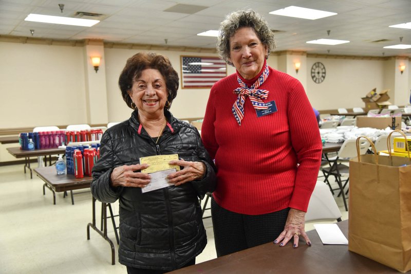 Auxiliary Unit 28 member Roberta Halle Bass, 2025 Unit Member of the Year, left, presents donations to Auxiliary Unit 28 Vice President Beth McGinn.