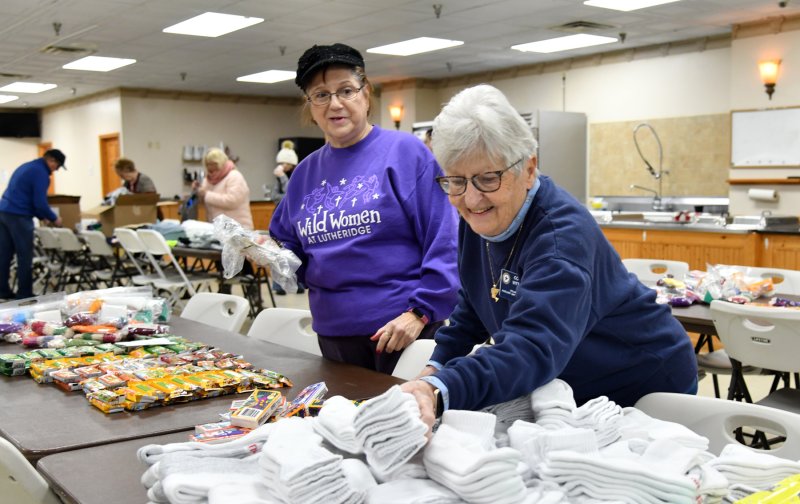 Auxiliary members Kathy Kendzietski, left, and Colleen Vittorino team up to stock the bags.